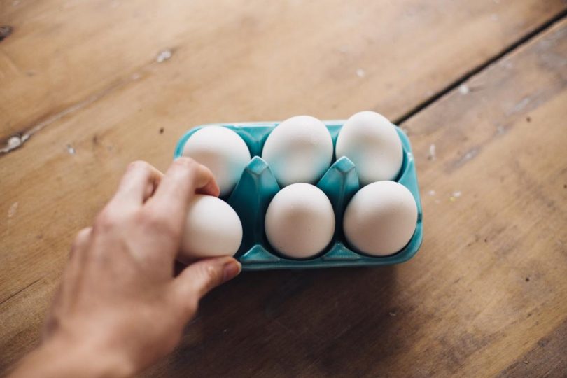 thumbnail hand reaching for an egg in an egg box 810x540